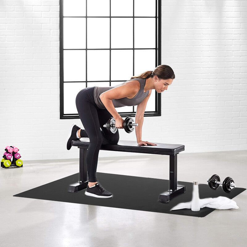 Woman exercising with dumbbells on a weight bench in a home gym setting.