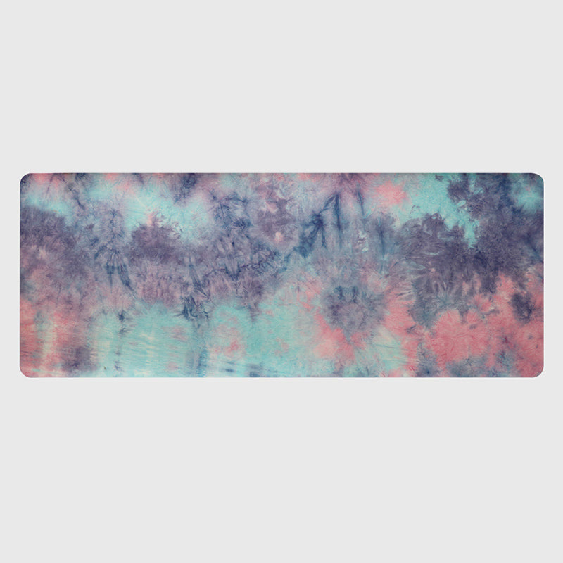 Yoga mat with tie-dye pattern in purple, blue, and pink on a light gray background